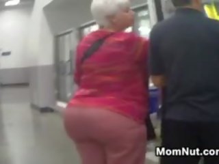 Liels vecmāmiņa pakaļa spied par pie the veikals